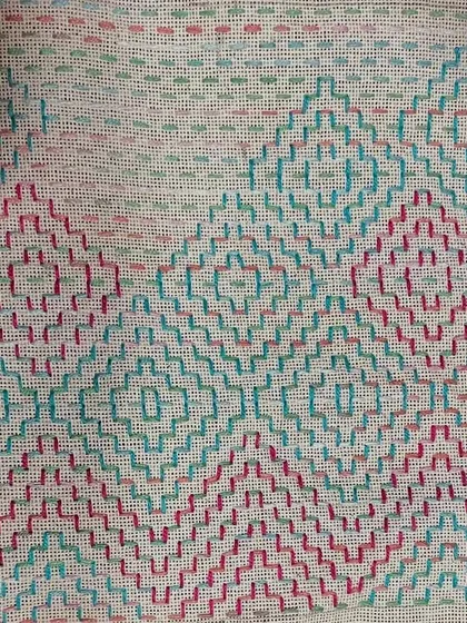 The pattern on this pouch is a beautiful example of how simple stitches can be combined to create complex and visually interesting designs.