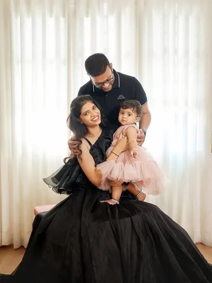 A beautiful family portrait. The mother is wearing our black ballgown with modern, structured sleeves, coordinating perfectly with her family.