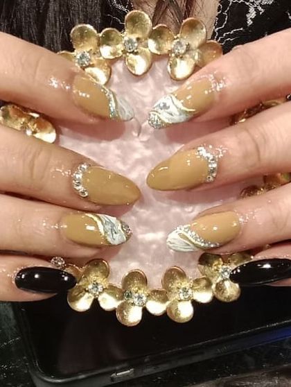 A bold set combining black, nude, and white marble nails, all accented with rhinestones at the cuticle.