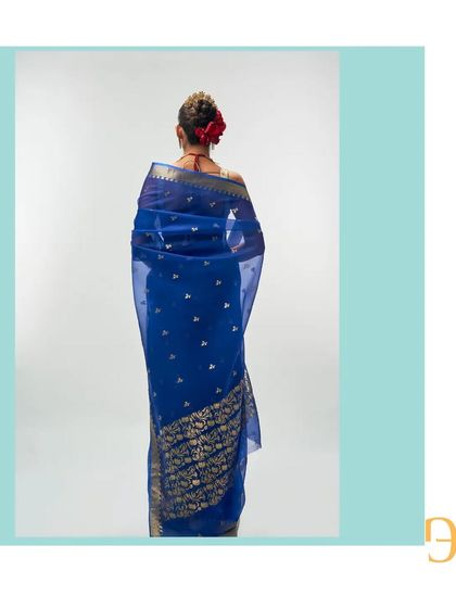 A back view of the cerulean blue saree, showing the rich floral motif woven into the pallu with pure gold zari.