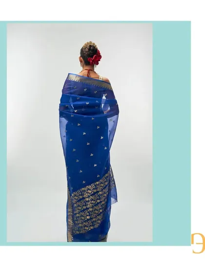 The back of the cerulean blue saree highlights the dense floral motif on the pallu, a testament to the weaver's skill.