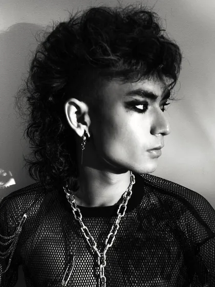 A profile shot from the same series, highlighting the mullet hairstyle and the model's strong jawline. The lighting is clean and graphic.