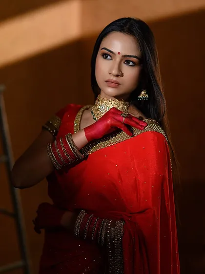 This shot highlights the cultural significance of red in Indian traditions. The model's hands, colored with alta, are brought into focus, adding a layer of storytelling to the portrait.
