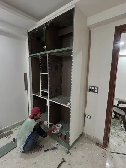 A carpenter from our team meticulously working on a custom wardrobe. We build storage solutions on-site to ensure a perfect fit and finish, tailored to the room's dimensions.