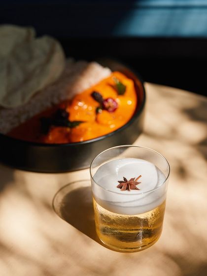 The finished Cuban Sour, perfectly paired with a comforting Indian meal. It's a versatile cocktail that's refreshing enough for the afternoon and complex enough for the night.