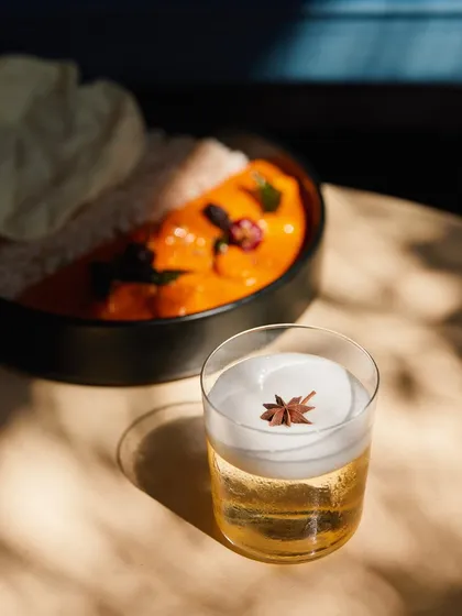 The finished Cuban Sour, perfectly paired with a comforting Indian meal. It's a versatile cocktail that's refreshing enough for the afternoon and complex enough for the night.
