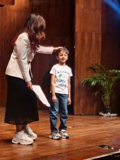 A moment of encouragement from a teacher to a student right before he receives his certificate on stage.