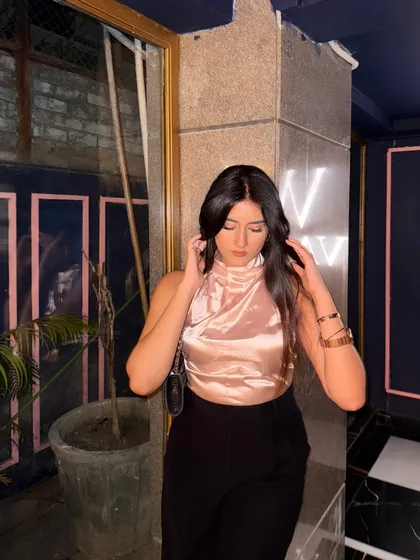 "To be loved by me is a privilege." A chic brunch outfit with a rose-gold satin halter top and black trousers.