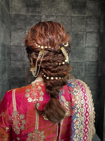 A hairstyle should be a work of art. This intricate textured braid, woven with delicate pearl accessories, was designed to be both beautiful from all angles and sturdy enough to last through a full day of celebrations.