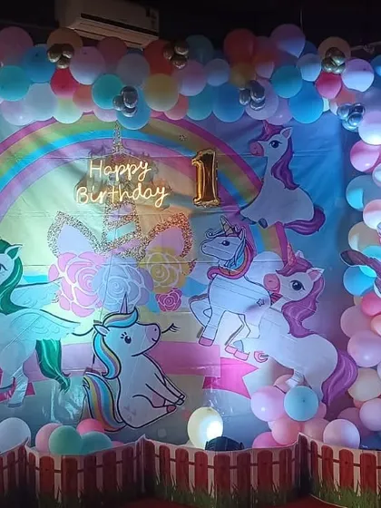 A magical unicorn and rainbow themed birthday backdrop, filled with colorful balloons and unicorn illustrations.