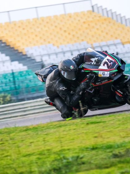 A rider on a black superbike leans hard into a corner against the backdrop of the BIC grandstands, a familiar sight for our track day participants.