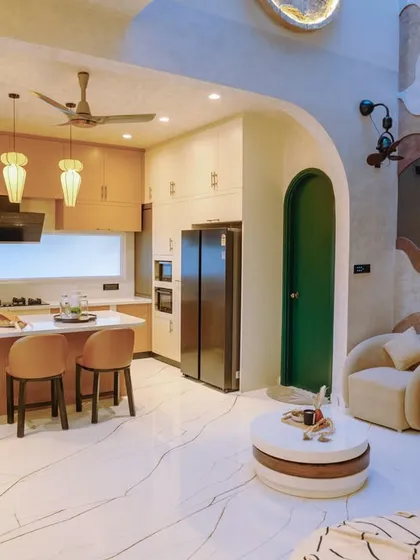 Our design philosophy is about creating spaces that flow. This open-concept area seamlessly connects the living room and a bespoke kitchen, unified by organic curves, a warm colour palette, and a double-height wall that adds a sense of grandeur.