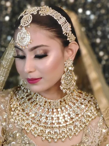 A full champagne-gold bridal set, including a heavy choker, matha patti, and large earrings. This look is pure royalty and is available for rent.