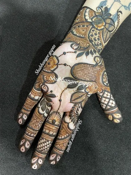 A custom design for Diwali. This piece has a modern feel, with abstract floral and leaf patterns that flow diagonally across the hand. It shows how versatile henna can be.