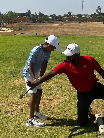 A coach helps a junior player with his setup. We believe in educating players so they can learn to self-correct.