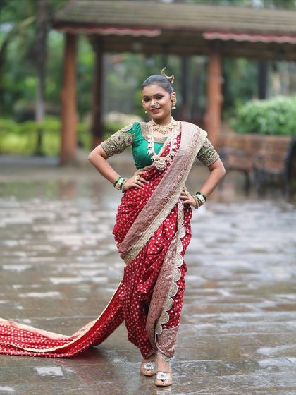 A confident bridal pose, showing the full effect of the red Nauvari and green blouse combination.