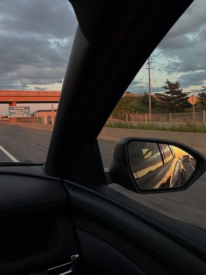 A shot from the passenger seat of a car during a golden hour drive. This aesthetic, in-the-moment capture is a staple of lifestyle content.