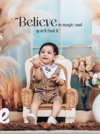 Believing in magic on his first birthday. This studio portrait captures a moment of wonder with a soft, dreamy backdrop and classic props.
