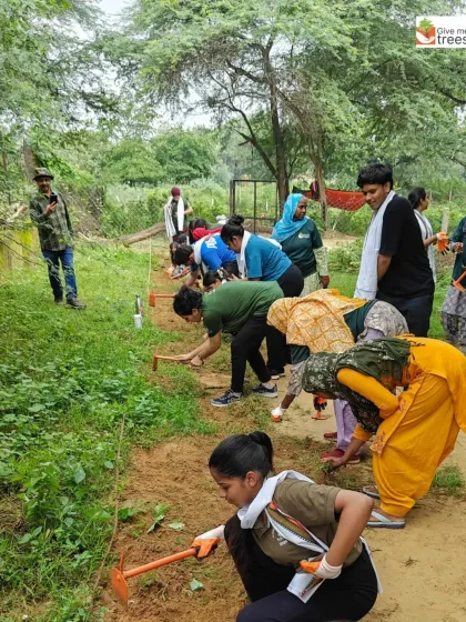 A diverse group of volunteers, including women from the local community and Amdocs employees, work together on a maintenance task. This blending of corporate and local volunteers creates a powerful sense of shared purpose.