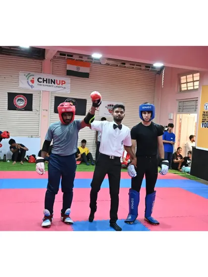 The referee raises the winner's hand, a moment of triumph for our athlete after a hard-fought final at the Mumbai City Championship.