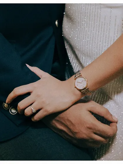 Sometimes, the smallest details tell the biggest story. This close-up of the couple's hands shows the engagement ring, the watch, the texture of their outfits. It’s a quiet, intimate detail from their stylish cocktail night.
