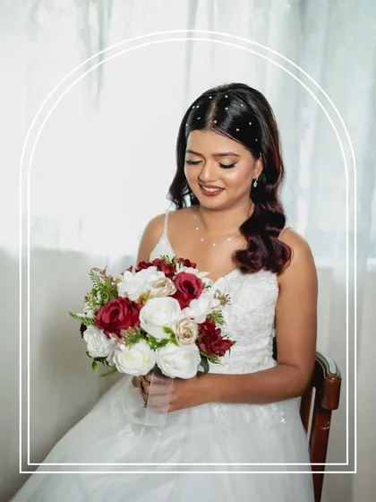 A serene portrait of the bride holding her bouquet. The soft, natural makeup and simple hairstyle create a look of pure elegance and grace.