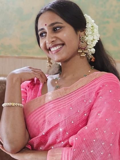 A smiling portrait in a lovely pink saree.