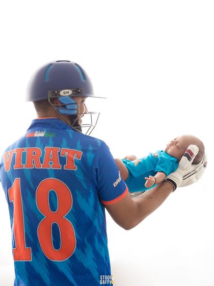 For the love of cricket! A father dressed in a Virat Kohli jersey holds his newborn, a perfect shot for a cricket-loving family welcoming their newest team member.