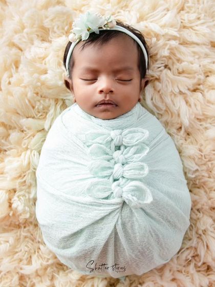 A simple and elegant wrap in a pastel mint green, featuring a series of small knots for a unique textural detail.