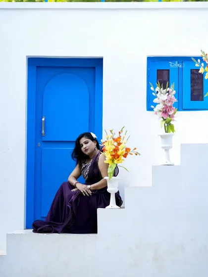 A serene portrait at our Santorini-themed set. The vibrant blue door and flowers create a beautiful, picturesque scene.