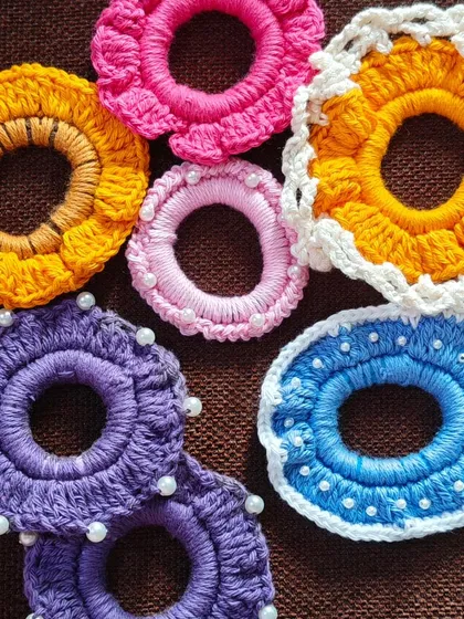 A collection of my crochet scrunchies, showcasing the different styles and colors I offer. From pearls to floral designs, there's something for everyone.