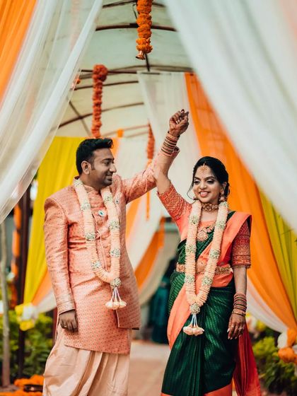 A celebratory shot of a couple walking down the aisle after their ceremony, with the bride raising her hand in triumph.