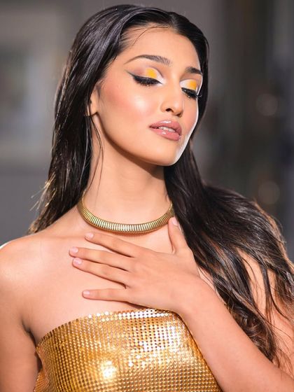 The wet hair look combined with the graphic eye gives this a high-fashion, editorial feel. We train our students in a wide range of styles to make them versatile artists.