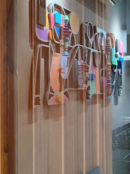 The 'Onwards and Upwards' installation seen from an angle, highlighting its three-dimensional quality as it projects from the wall.