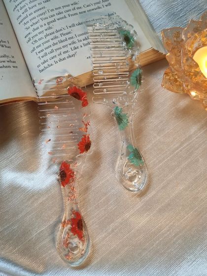 These clear resin combs are embedded with tiny, colorful flowers. I used red and green daisies to create a playful and pretty design, turning a simple hair accessory into something special.