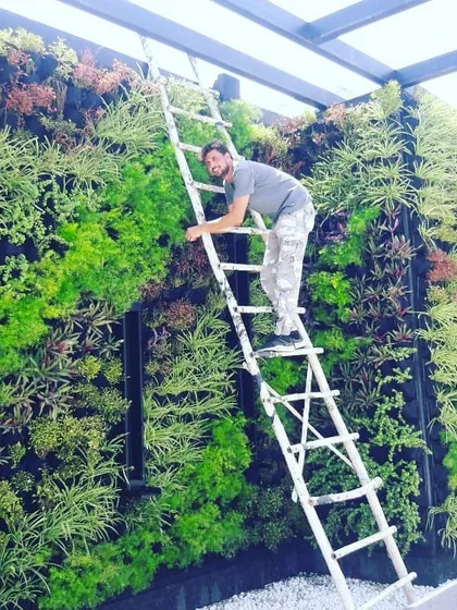 Here I am, putting the finishing touches on a large-scale natural vertical garden. Every project gets my personal attention to ensure the plants are healthy and the design is perfect.
