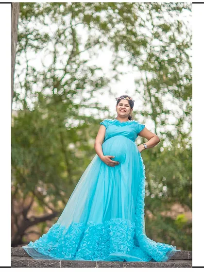 A side view of the light blue gown, showing off its lovely train and the beautiful silhouette of the expecting mother.