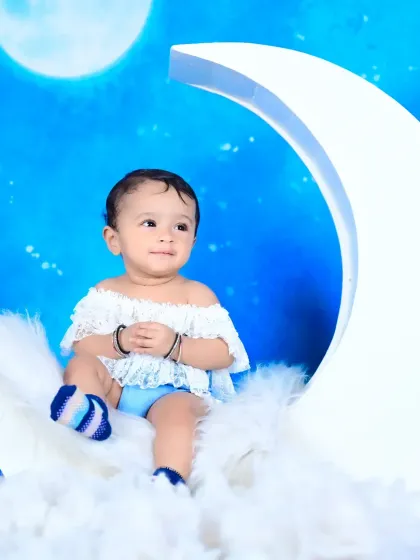 A serene photo from the "baby on the moon" theme, with the baby sitting peacefully among the clouds.