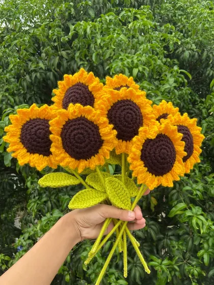 A bouquet of seven bright sunflowers, handmade and ready to brighten someone's day.