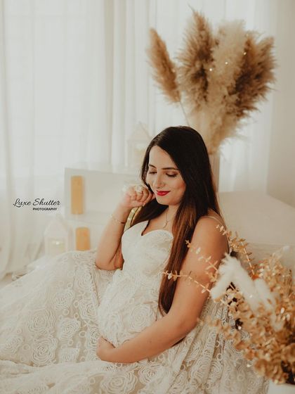 A quiet, contemplative moment captured in a beautiful lace gown, with warm, golden-hour style lighting.