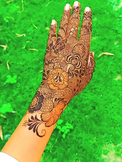 This design features a beautiful butterfly at the wrist, flowing into a full hand of floral and traditional patterns. A perfect example of a personalized touch.