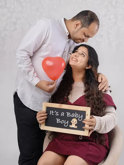 Celebrating their baby boy with a heart balloon and a happy announcement. This sweet and simple studio shot is a lovely way to capture their joy.