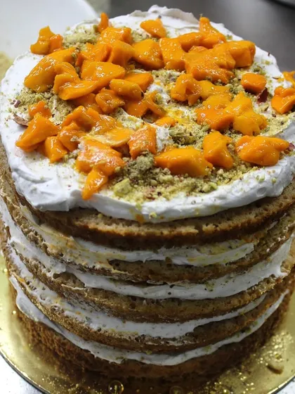 A peek at the making of our Mango Pistachio cake. You can see the layers of sponge being filled with fresh cream, mango chunks, and crushed pistachios.