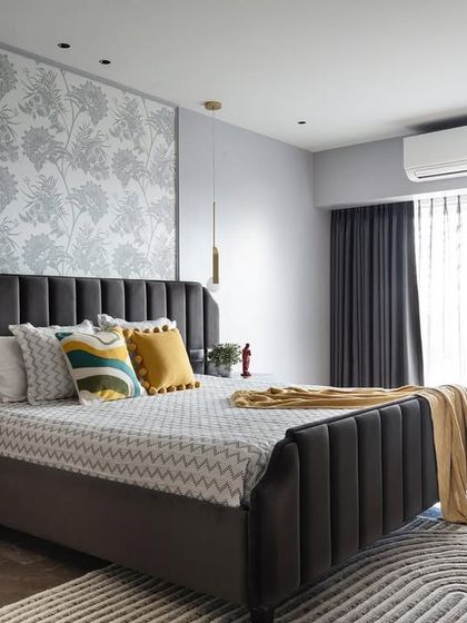 Chic and subtle, this bedroom design pairs a sophisticated grey palette with playful pops of yellow. The channel-tufted headboard adds texture, while the vibrant yellow armchair creates a cheerful and stylish reading nook.