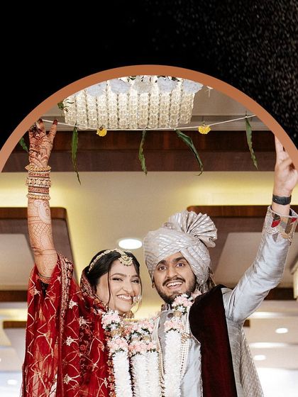 The couple celebrating their union, hands raised in joy. A perfect fairytale moment.