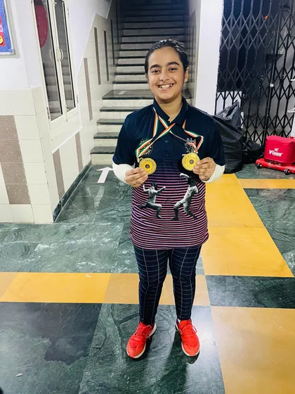 A double gold medalist from the girls' championship, proudly showing her well-earned rewards.