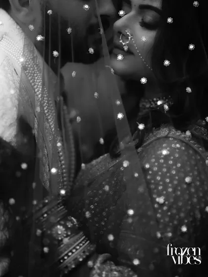 A moment of quiet intimacy between Nimit and Himani, captured in timeless black and white. The delicate veil adds a layer of artistry, focusing purely on the emotion and connection shared between them.