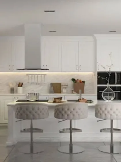This luxurious all-white island kitchen is the epitome of timeless elegance. The design includes a breakfast counter with plush seating, extensive cabinet storage, and integrated high-end appliances, creating a bright and sophisticated culinary hub.