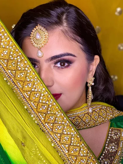 A playful and mysterious shot from the Roka ceremony. The focus is on the intense eye makeup, which stands out beautifully against the bright yellow of her dupatta.