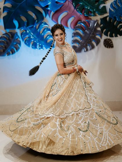 A happy bride twirling in her stunning lehenga. Our job is to create the perfect stage for her to shine, with backdrops that complement her style and energy.